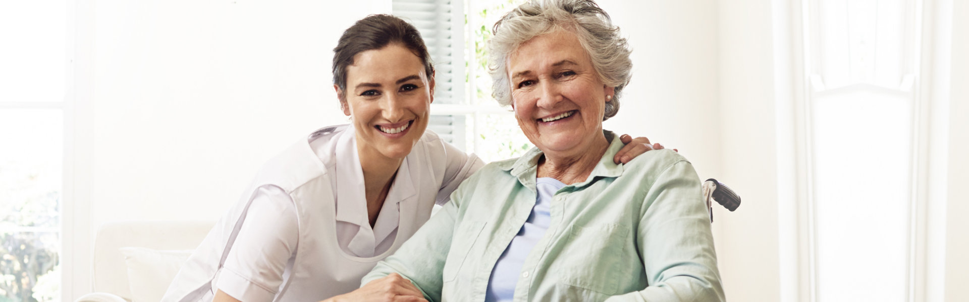 elderly woman and nurse looking at the camera